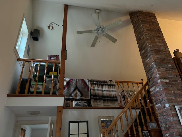 stairway featuring ceiling fan and a high ceiling