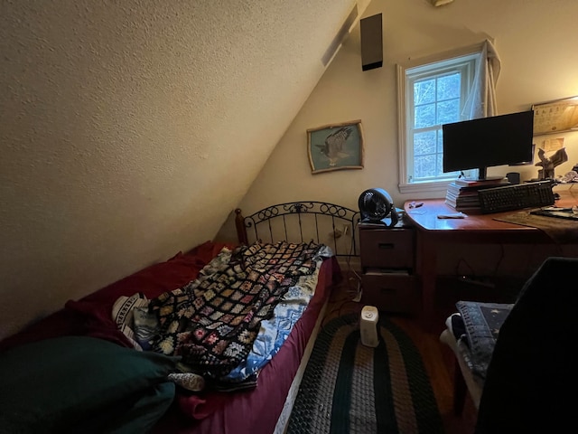 bedroom with vaulted ceiling and a textured ceiling