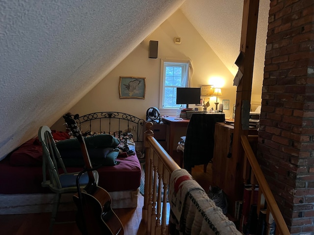 bedroom with lofted ceiling and a textured ceiling