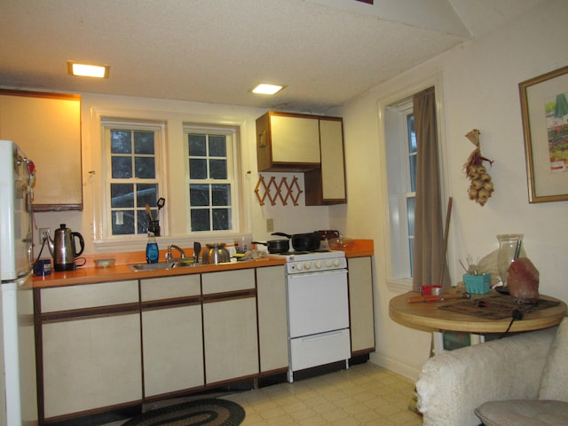 kitchen featuring a textured ceiling and white appliances