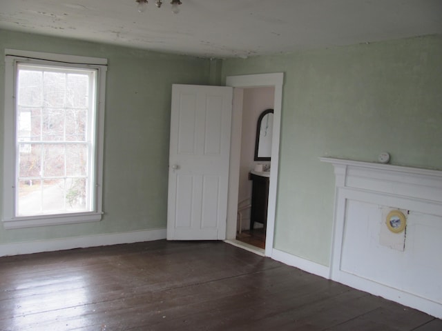 empty room with dark hardwood / wood-style flooring and a wealth of natural light