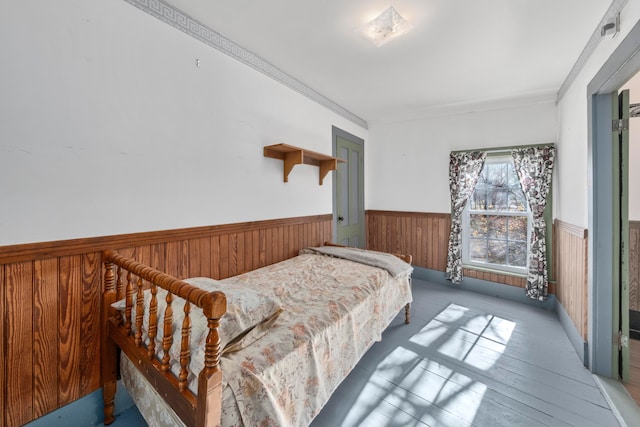 bedroom featuring wooden walls and ornamental molding