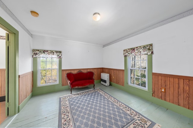 sitting room with wood walls, ornamental molding, and light hardwood / wood-style flooring