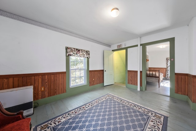 unfurnished room featuring heating unit, wood walls, and hardwood / wood-style flooring