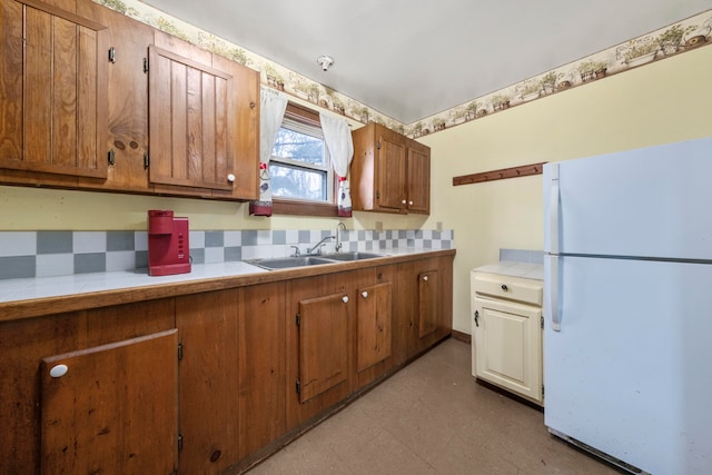 kitchen with tasteful backsplash, sink, and white refrigerator