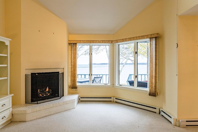 9 Jameson Point Rd Unit 10, Rockland, ME 04841 - unfurnished living room featuring carpet flooring, healthy amount of natural light, vaulted ceiling, a fireplace, and a water view