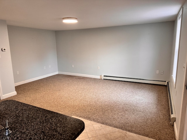 carpeted spare room with a baseboard radiator