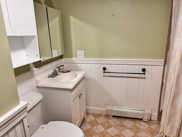 bathroom featuring vanity, toilet, and baseboard heating