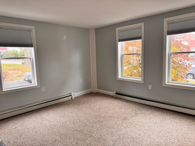 carpeted spare room with a healthy amount of sunlight and a baseboard radiator