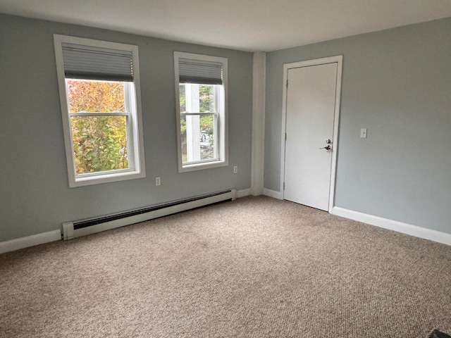 carpeted spare room featuring a baseboard radiator