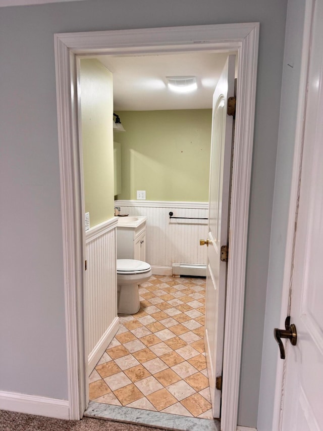 bathroom featuring vanity, toilet, and a baseboard heating unit