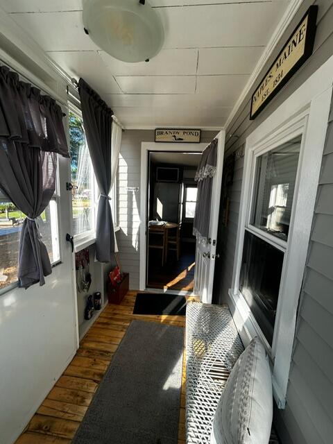 corridor with dark hardwood / wood-style floors and wooden walls