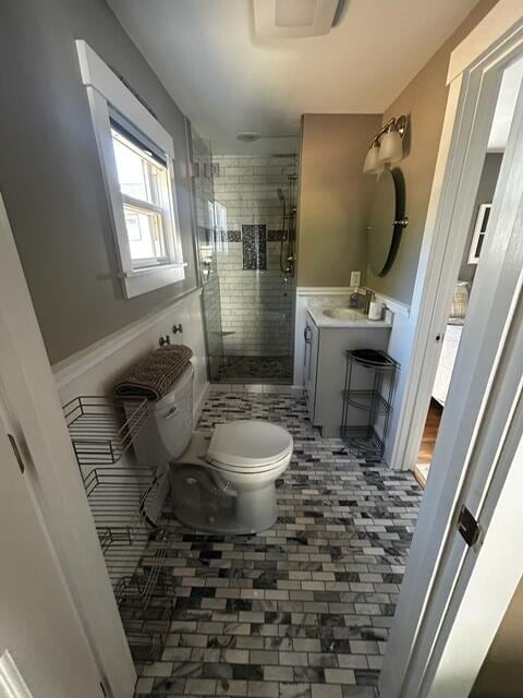 bathroom featuring tile patterned floors, vanity, toilet, and a shower with door