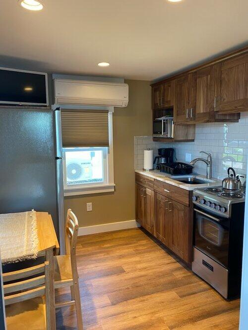 kitchen featuring light hardwood / wood-style floors, sink, appliances with stainless steel finishes, and tasteful backsplash