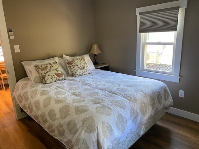 bedroom with dark wood-type flooring