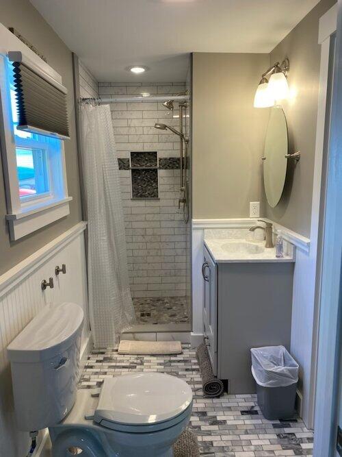 bathroom with tile patterned floors, a shower with curtain, vanity, and toilet