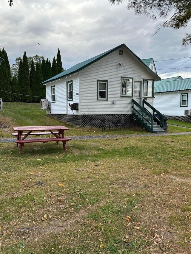 view of front of property with central AC unit and a front lawn