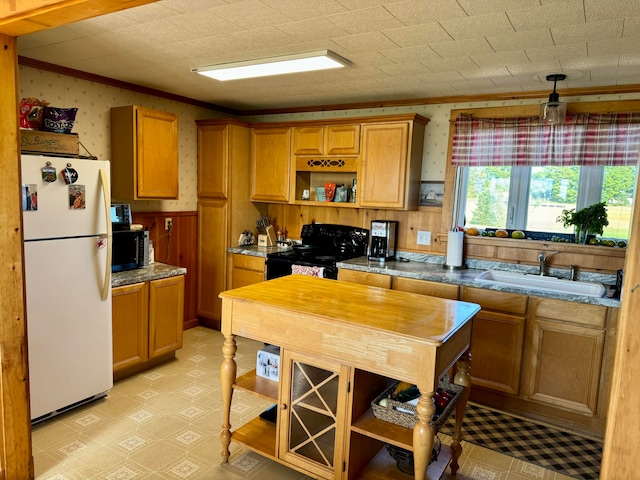 kitchen with sink, crown molding, black electric range, and white fridge