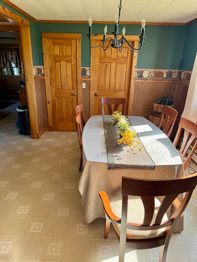 dining space featuring ornamental molding, a notable chandelier, and wooden walls