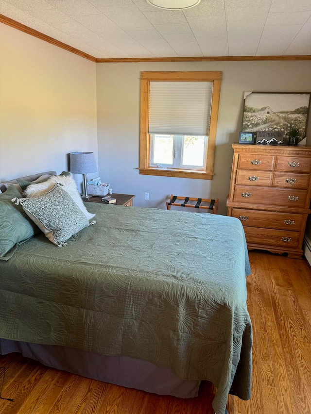 bedroom featuring crown molding and hardwood / wood-style flooring