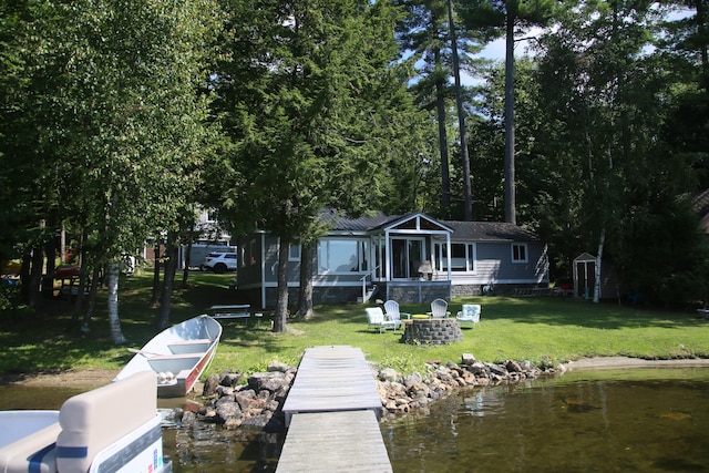 dock area featuring a yard, a water view, and an outdoor fire pit