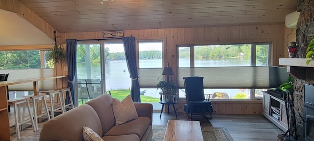 living room with a wealth of natural light, a water view, wood ceiling, and hardwood / wood-style flooring