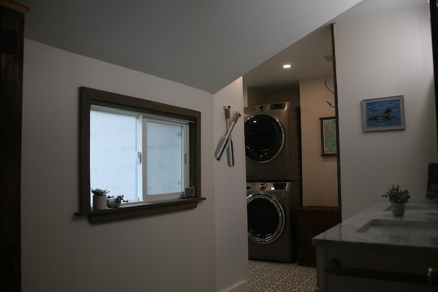 laundry room with stacked washer / drying machine and sink