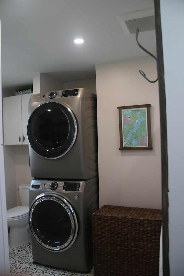 clothes washing area with stacked washer / dryer