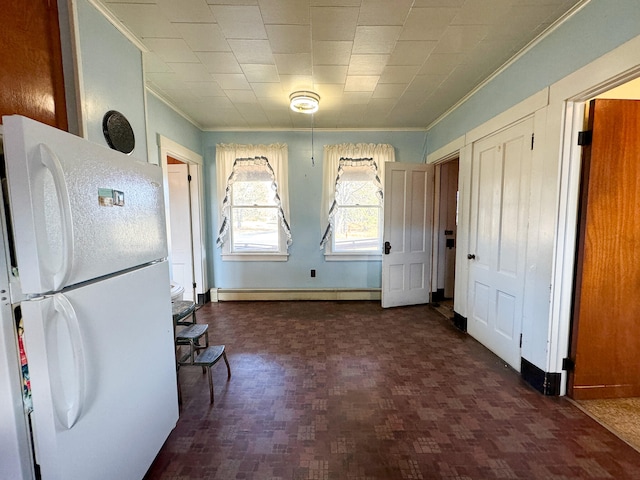 kitchen featuring white refrigerator, crown molding, and a baseboard heating unit