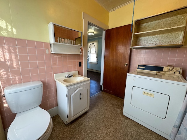 interior space with vanity, washer / clothes dryer, toilet, and tile walls