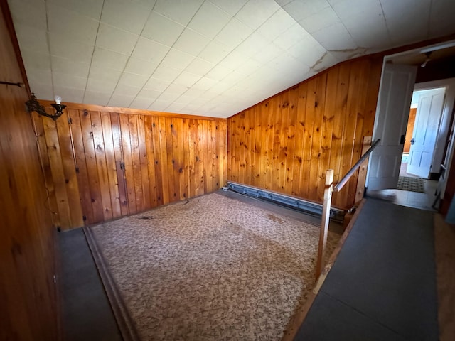 additional living space featuring carpet flooring, wooden walls, and lofted ceiling