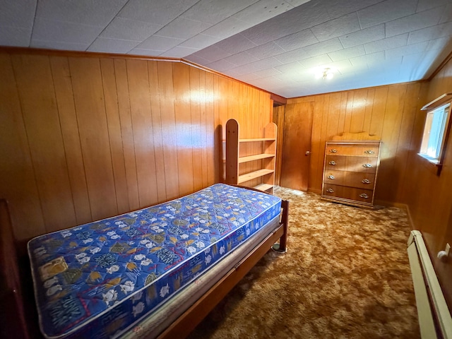 bedroom with carpet, baseboard heating, wooden walls, and vaulted ceiling