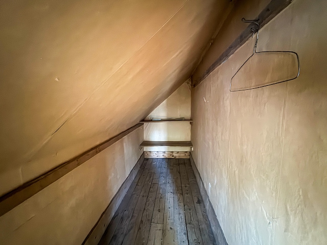 additional living space with dark hardwood / wood-style floors and vaulted ceiling