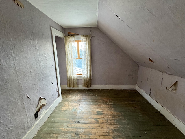 additional living space with dark hardwood / wood-style flooring and lofted ceiling