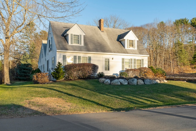 cape cod house featuring a front yard