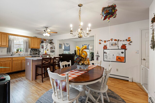 dining area with a baseboard radiator, ceiling fan with notable chandelier, and light hardwood / wood-style floors