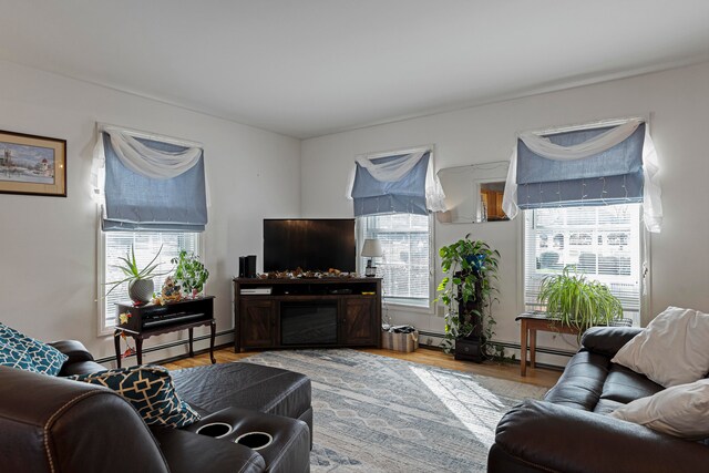 living room with light wood-type flooring and a baseboard heating unit