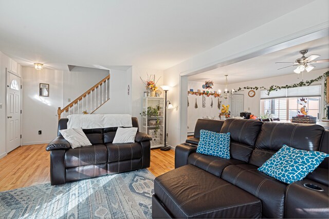 living room featuring hardwood / wood-style floors and ceiling fan with notable chandelier