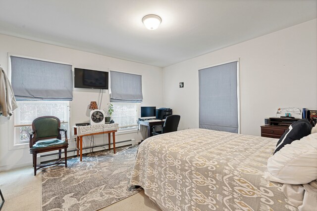 bedroom with light colored carpet and a baseboard radiator