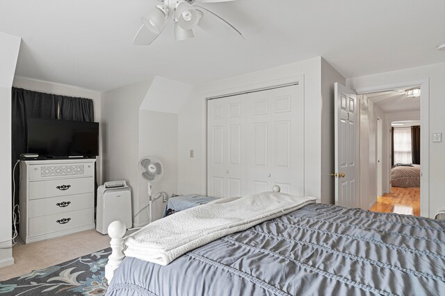 carpeted bedroom with ceiling fan and a closet