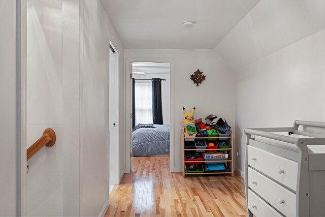 bedroom featuring light hardwood / wood-style floors and lofted ceiling