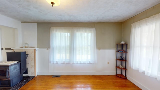 living room featuring hardwood / wood-style floors, a wood stove, and a wealth of natural light