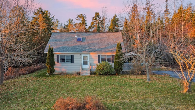 cape cod-style house with a lawn