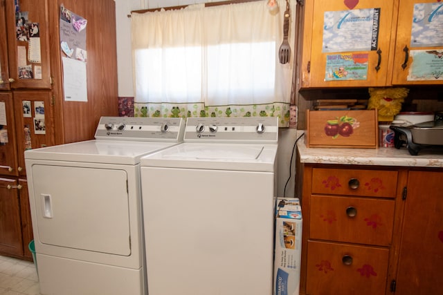 laundry room featuring washing machine and clothes dryer and cabinets