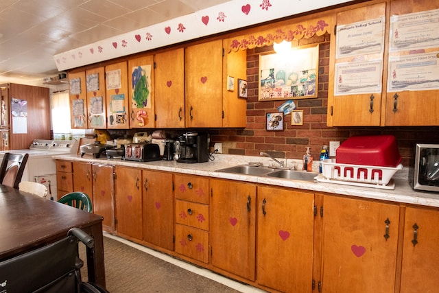 kitchen featuring carpet flooring, washer / dryer, and sink