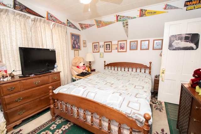 carpeted bedroom with ceiling fan and vaulted ceiling