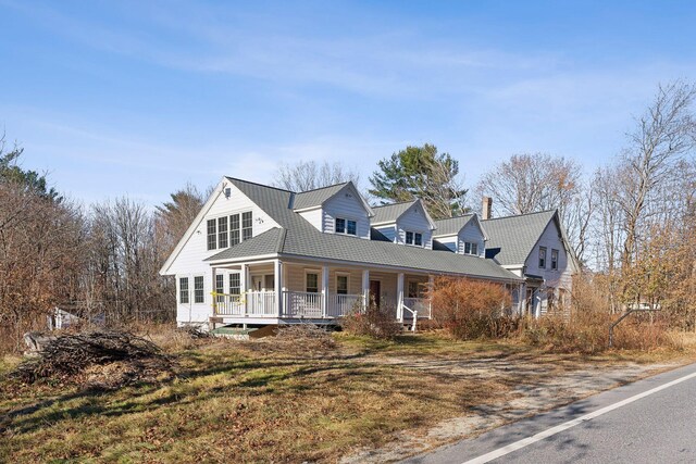 cape cod home featuring a porch