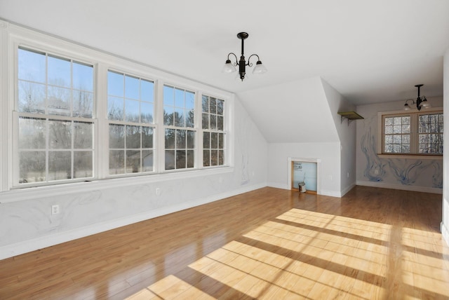 454 N Parish Rd, Turner, ME 04282 - bonus room with hardwood / wood-style floors, vaulted ceiling, an inviting chandelier, and a healthy amount of sunlight