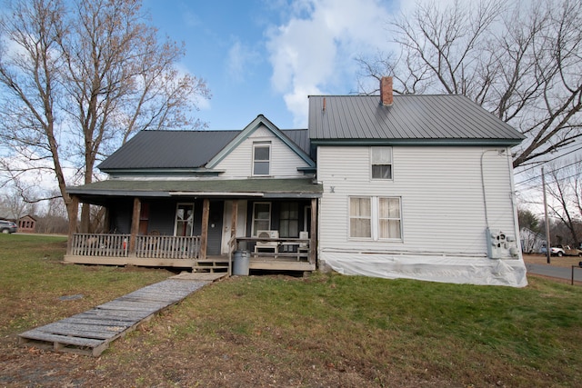 rear view of house featuring a yard