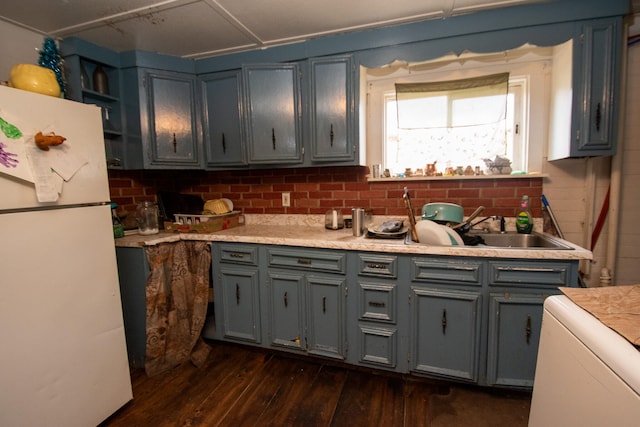 kitchen featuring dark hardwood / wood-style floors, white refrigerator, and sink